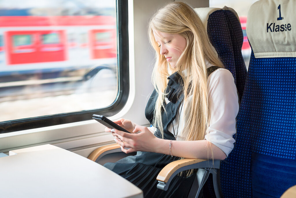 Chica en el tren con una tableta