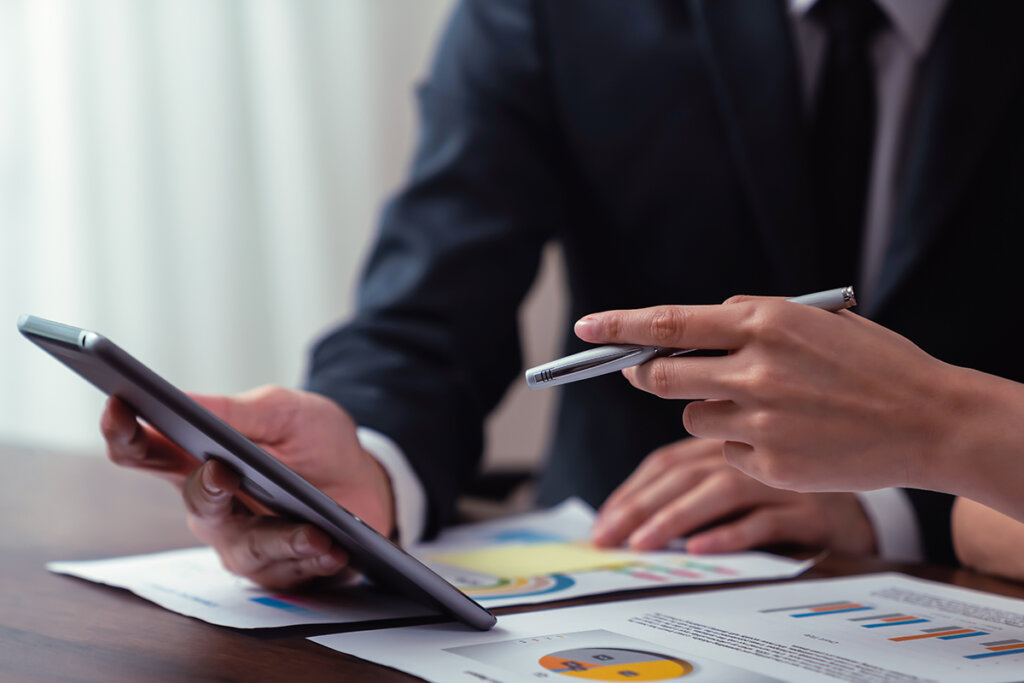 Dos personas trabajan con una tableta en un entorno empresarial.