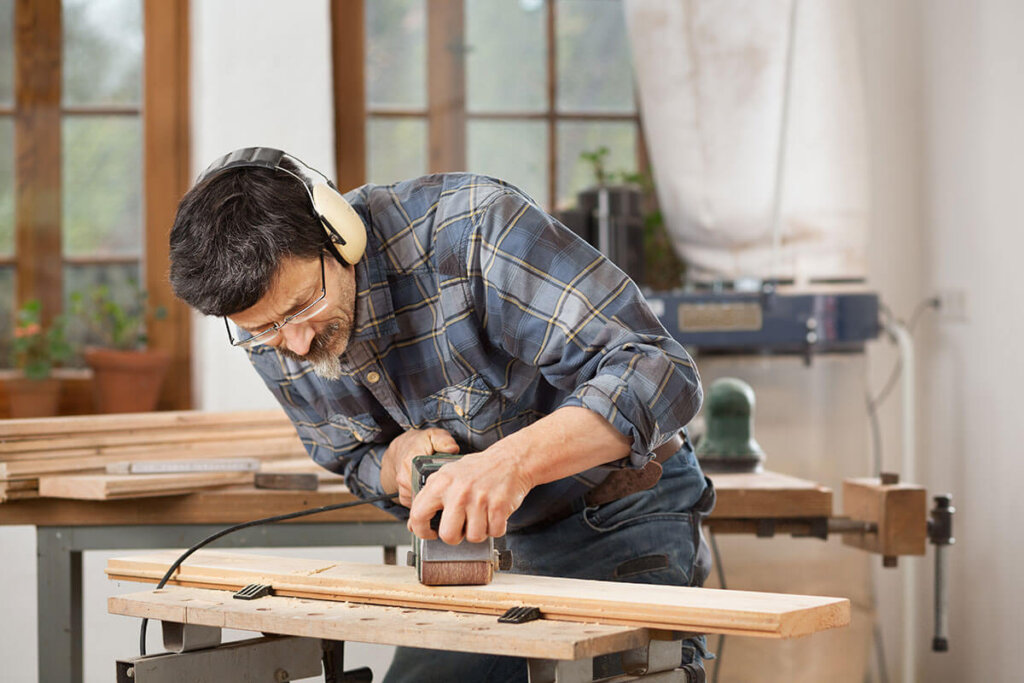 Persona lijando tabla de madera