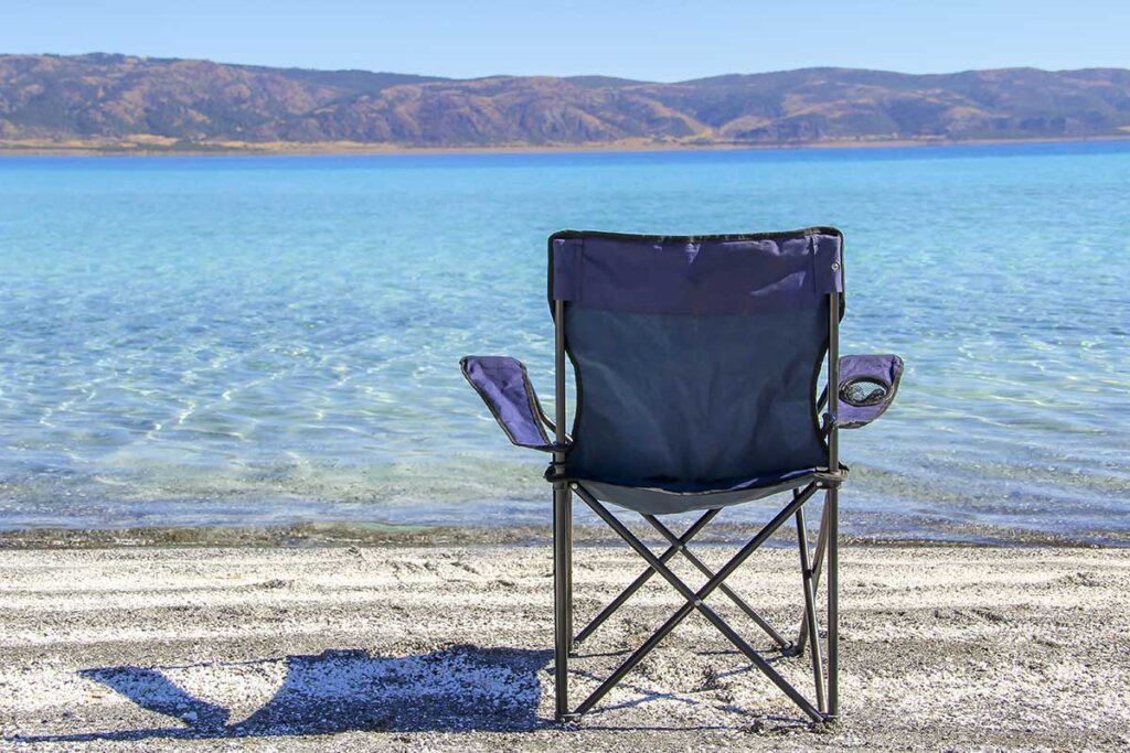 silla de camping azul en la playa