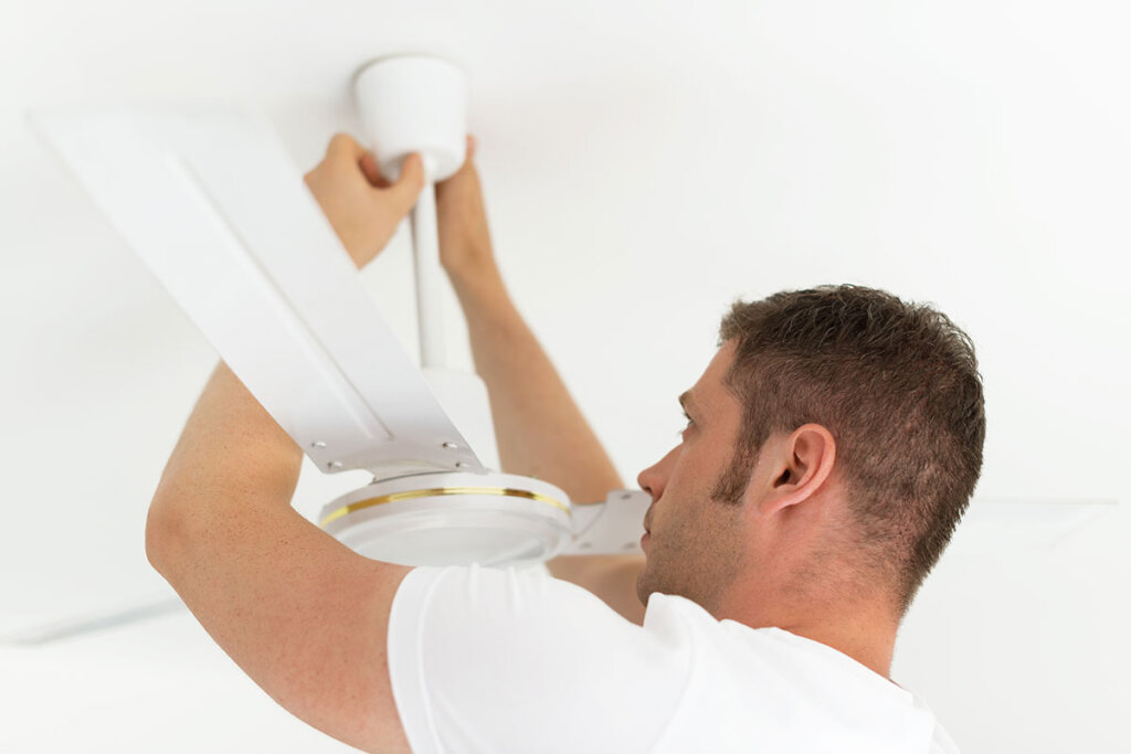 Un hombre instala un ventilador de techo