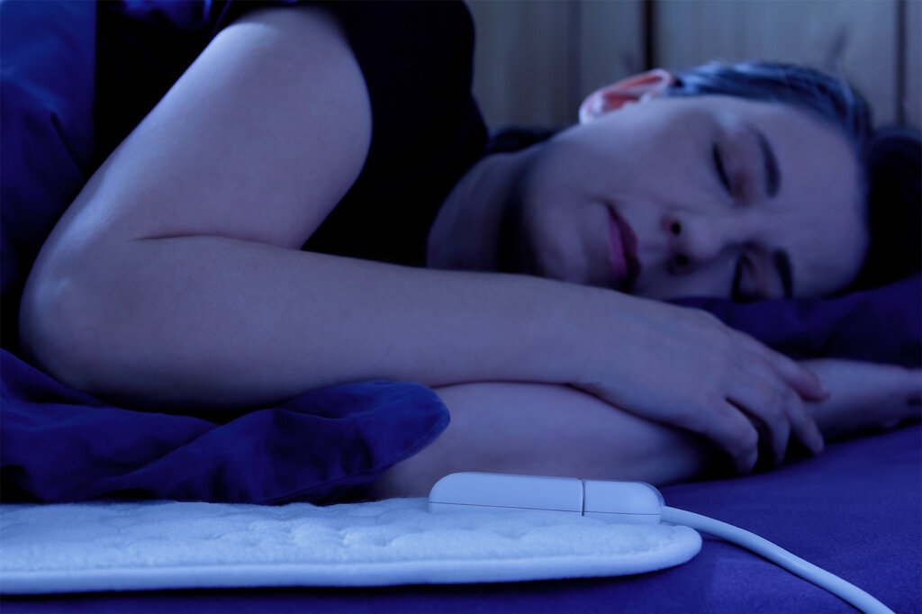 Mujer durmiendo sobre manta eléctrica