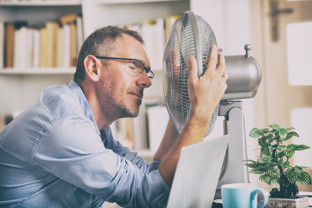 hombre frente a ventilador en oficina