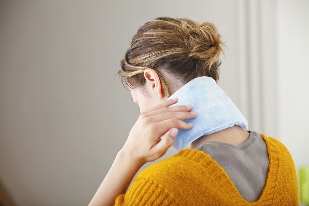 mujer tiene almohada calefactora en el cuello