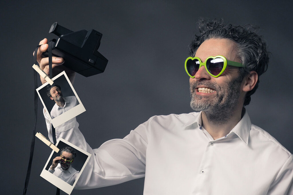 hombre con camara instantanea se hace selfies