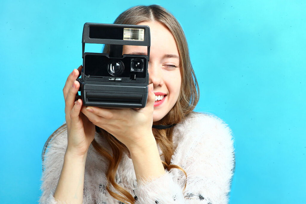 mujer toma una foto con una cámara instantánea