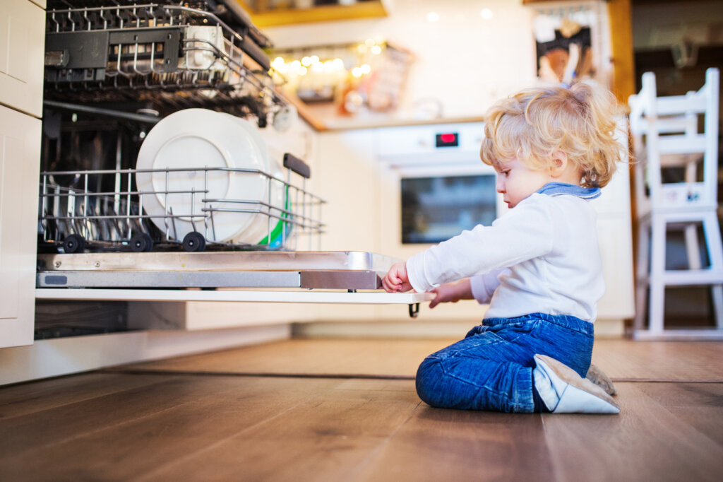 small_boy_sits_in_front_of_a_dishwasher