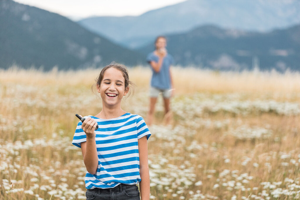 Dos hermanos jugando con walkie-talkies al aire libre