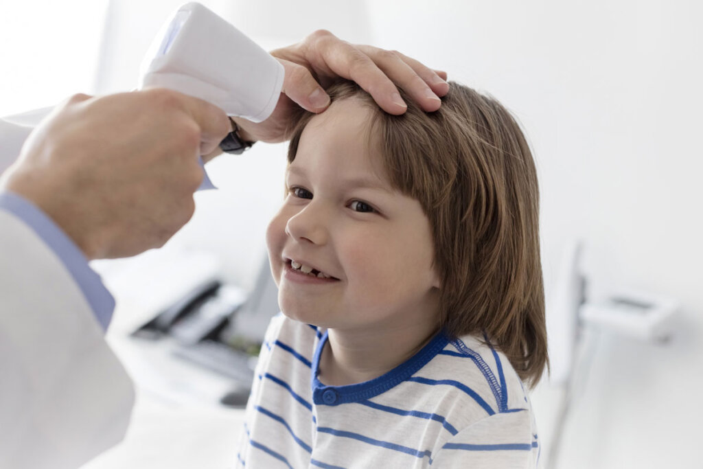 la temperatura de un niño se mide con un termómetro en la frente