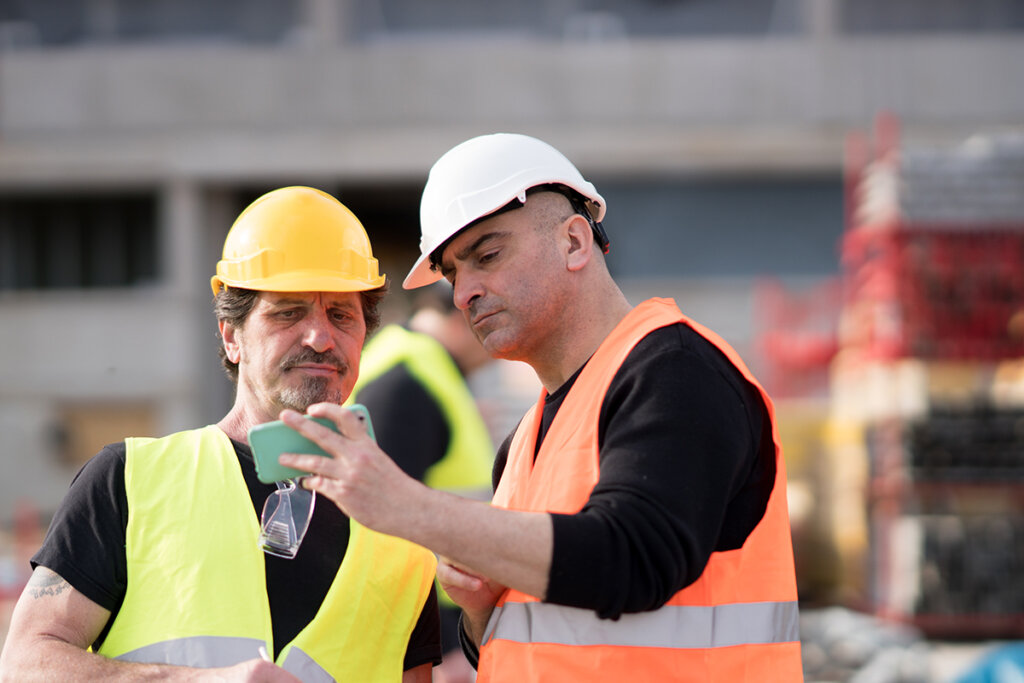 Trabajador de la construcción utilizando un smartphone en una obra