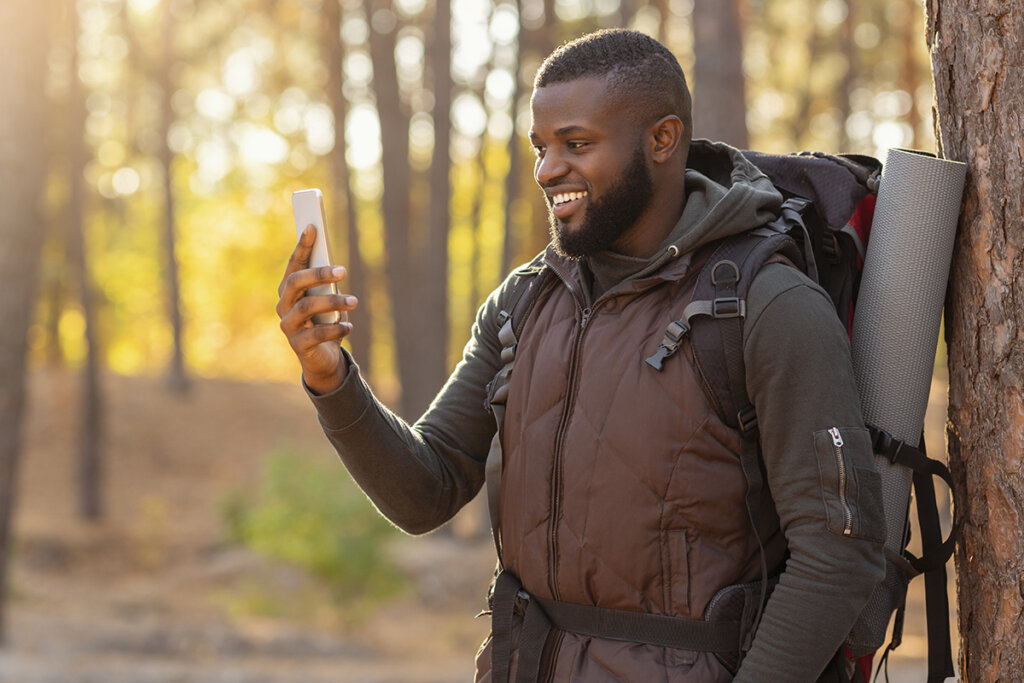 Hombre en el bosque mirando un smartphone