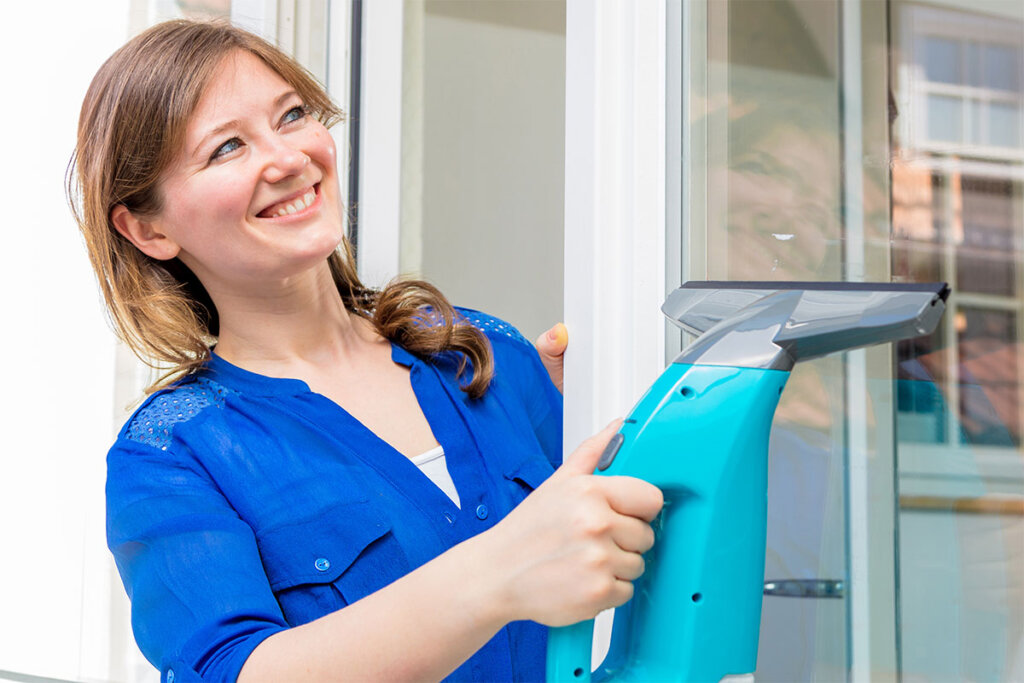 Mujer utiliza aspirador de ventanas